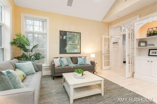 1749 Sunset Point Dr, Norton Shores, MI 49441 - living area with french doors, lofted ceiling, light wood-style floors, and baseboards