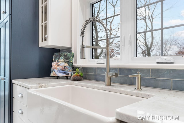 1749 Sunset Point Dr, Norton Shores, MI 49441 - kitchen view of a sink, backsplash, glass insert cabinets, and white cabinetry