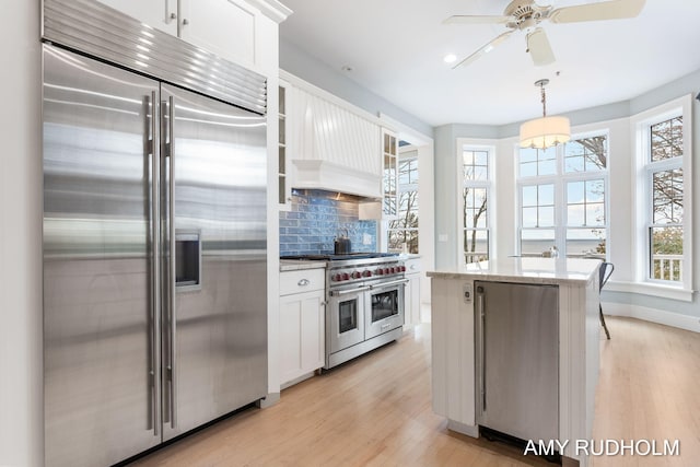 1749 Sunset Point Dr, Norton Shores, MI 49441 - kitchen with premium appliances, light wood-style floors, decorative backsplash, white cabinets, and recessed lighting
