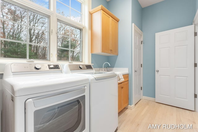 1749 Sunset Point Dr, Norton Shores, MI 49441 - washroom featuring cabinet space, separate washer and dryer, light wood-style floors, and baseboards