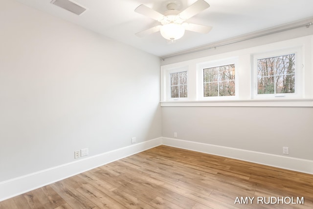 1749 Sunset Point Dr, Norton Shores, MI 49441 - spare room with baseboards, wood finished floors, and a ceiling fan