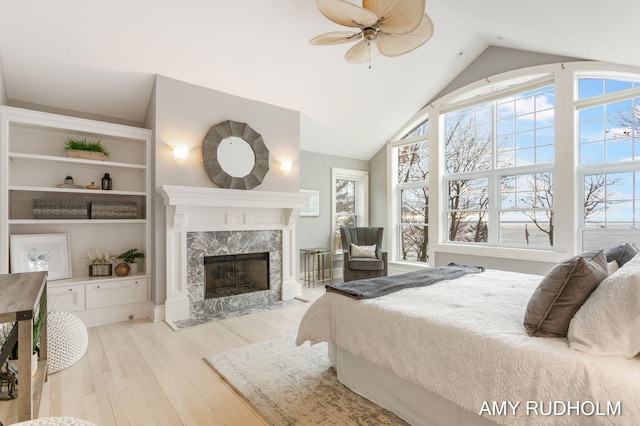 1749 Sunset Point Dr, Norton Shores, MI 49441 - bedroom with a fireplace, wood finished floors, multiple windows, high vaulted ceiling, and ceiling fan