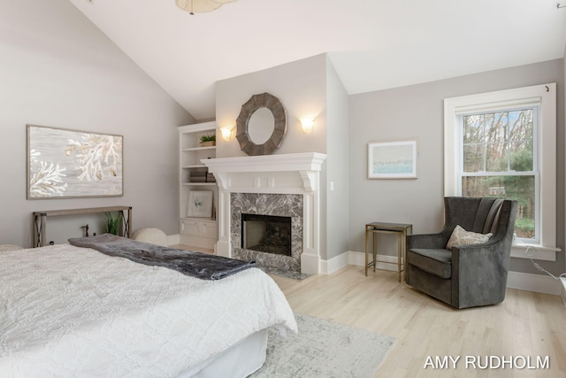 1749 Sunset Point Dr, Norton Shores, MI 49441 - bedroom featuring wood finished floors, vaulted ceiling, baseboards, and a fireplace