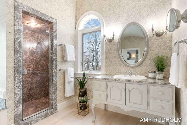 1749 Sunset Point Dr, Norton Shores, MI 49441 - bathroom featuring wallpapered walls, a stall shower, vanity, and wood finished floors