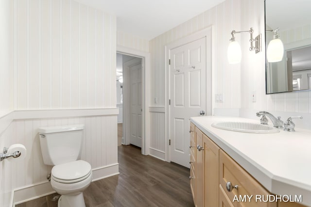 1749 Sunset Point Dr, Norton Shores, MI 49441 - bathroom featuring wallpapered walls, wood finished floors, toilet, vanity, and wainscoting