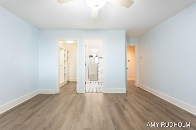 1749 Sunset Point Dr, Norton Shores, MI 49441 - unfurnished bedroom featuring wood finished floors, baseboards, a ceiling fan, and connected bathroom