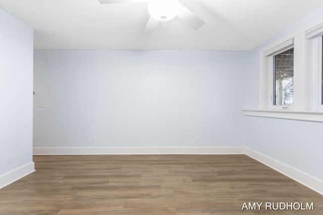 1749 Sunset Point Dr, Norton Shores, MI 49441 - spare room with baseboards, wood finished floors, and a ceiling fan