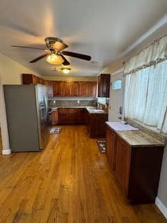 kitchen featuring ceiling fan, stainless steel refrigerator with ice dispenser, and light hardwood / wood-style flooring