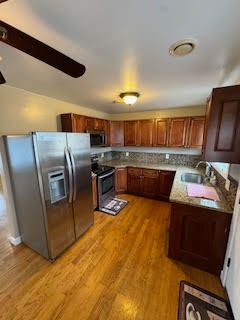 kitchen with sink, appliances with stainless steel finishes, and light hardwood / wood-style flooring