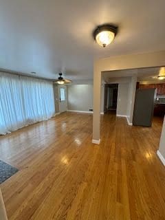 unfurnished living room featuring dark hardwood / wood-style floors and ceiling fan