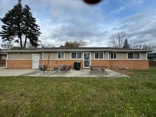 back of property with a patio area and a yard