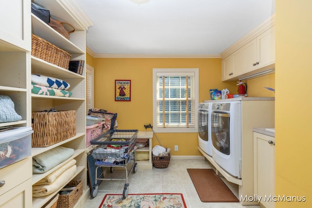 laundry area featuring washer and dryer, ornamental molding, light tile patterned floors, and cabinets