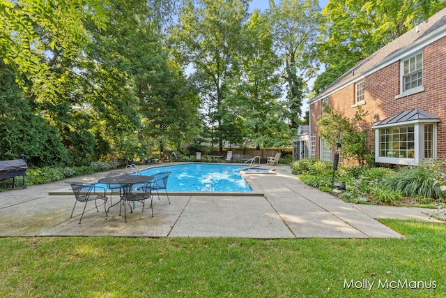 view of pool with a lawn and a patio area