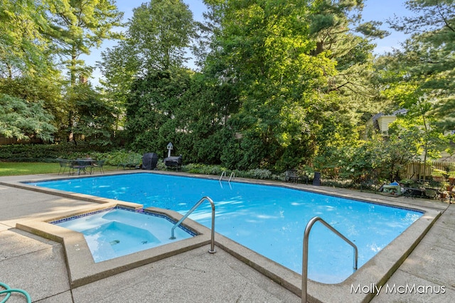 view of pool featuring an in ground hot tub