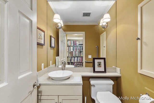 bathroom featuring vanity, toilet, and ornamental molding