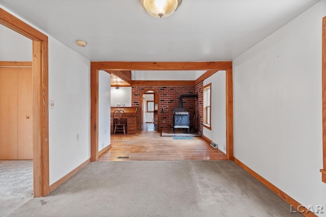 unfurnished living room with a wood stove and light hardwood / wood-style flooring