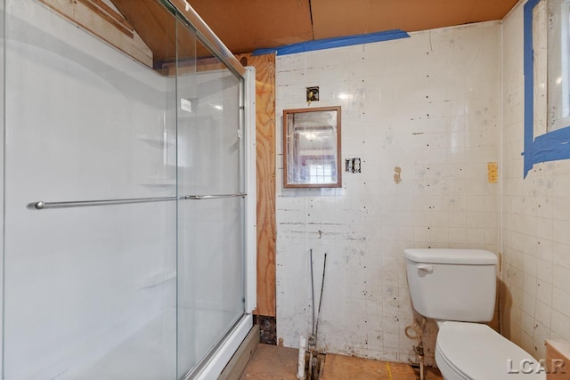 bathroom with tile walls, an enclosed shower, and toilet