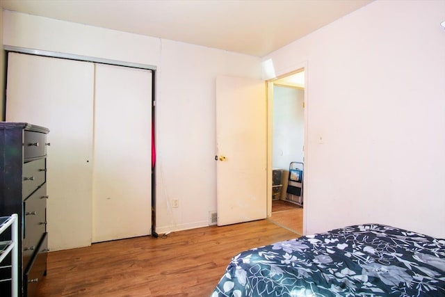 bedroom with wood-type flooring and a closet