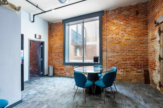 dining room featuring hardwood / wood-style flooring and brick wall