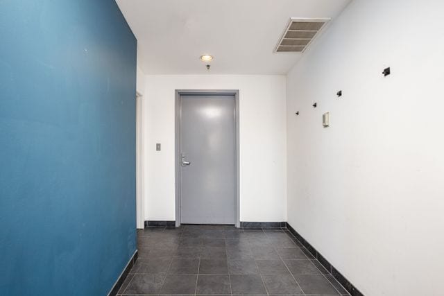 hallway featuring dark tile patterned flooring