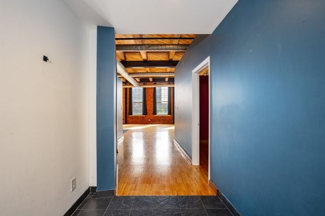 hall with wooden ceiling, beamed ceiling, and wood-type flooring