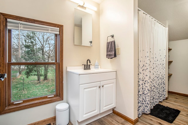 bathroom featuring vanity, wood-type flooring, a textured ceiling, and a wealth of natural light