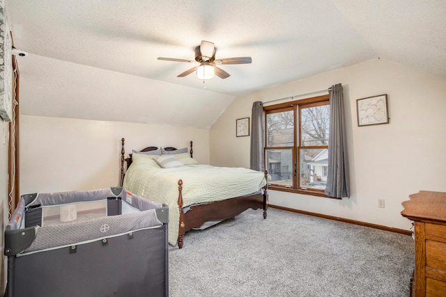 carpeted bedroom featuring a textured ceiling, vaulted ceiling, and ceiling fan