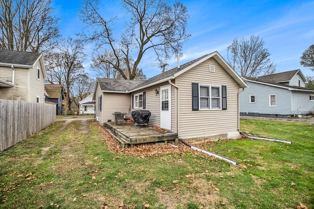 back of house featuring a deck and a lawn