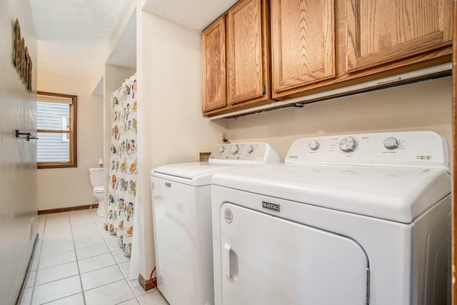 washroom with washer and clothes dryer, light tile patterned flooring, and cabinets