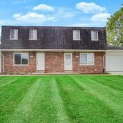 view of front of home with a front yard and a garage