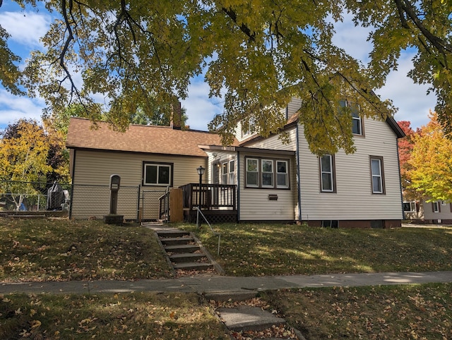 view of front of house with a wooden deck and a front lawn