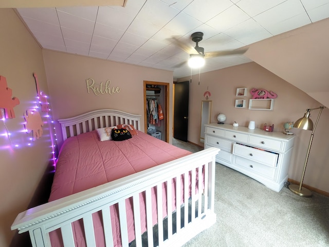 carpeted bedroom with a walk in closet, ceiling fan, a closet, and vaulted ceiling