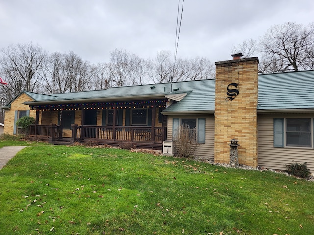 back of property featuring covered porch and a yard