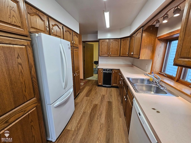 kitchen with pendant lighting, dark hardwood / wood-style floors, white appliances, and sink