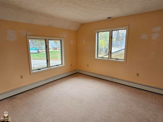 carpeted empty room featuring vaulted ceiling, a wealth of natural light, a textured ceiling, and baseboard heating