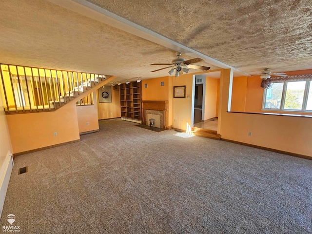 unfurnished living room featuring ceiling fan, carpet, and a textured ceiling