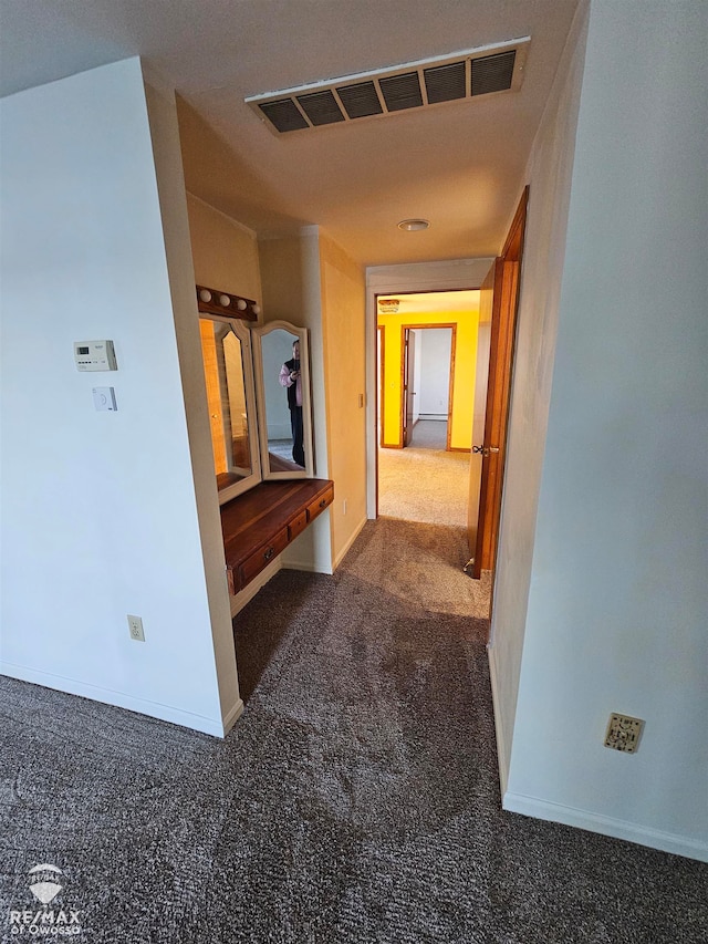 hallway with dark colored carpet