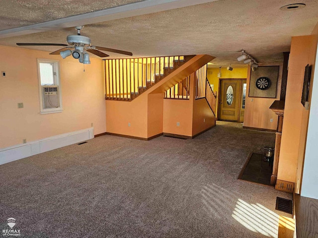 unfurnished living room with dark carpet, a textured ceiling, and track lighting