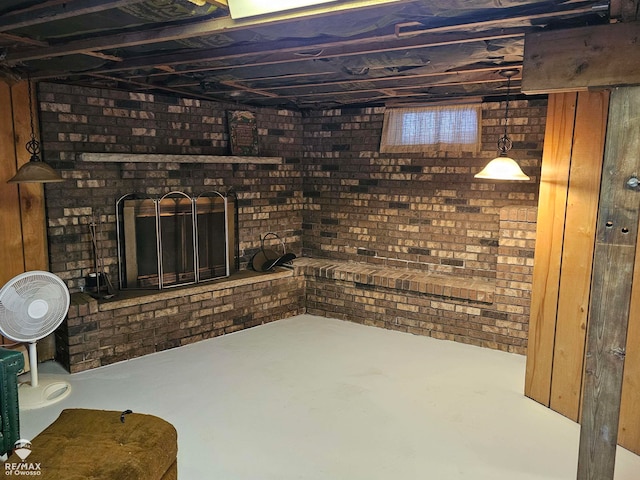 basement with brick wall and a brick fireplace