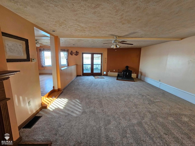 unfurnished living room with carpet flooring, ceiling fan, french doors, and a textured ceiling