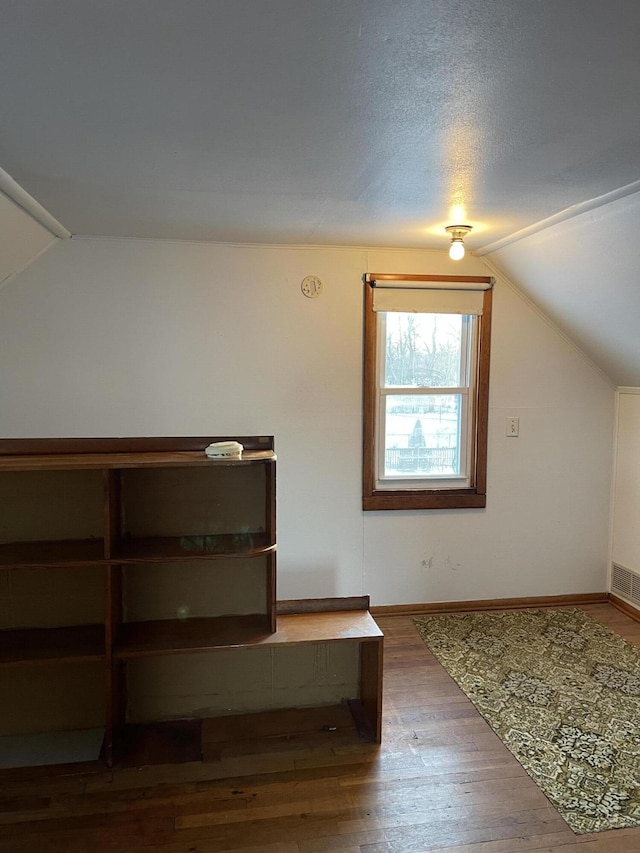 bonus room with hardwood / wood-style floors and lofted ceiling