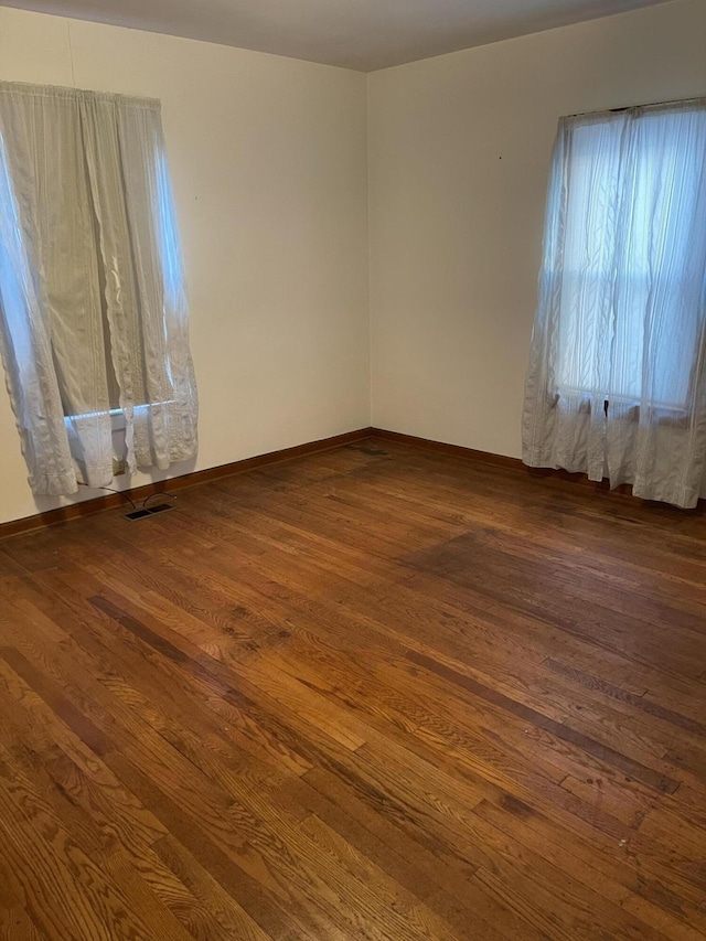 unfurnished room with dark wood-type flooring