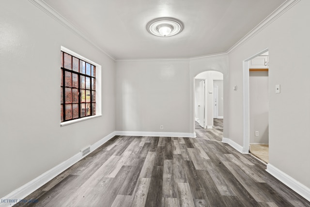 spare room with crown molding and wood-type flooring