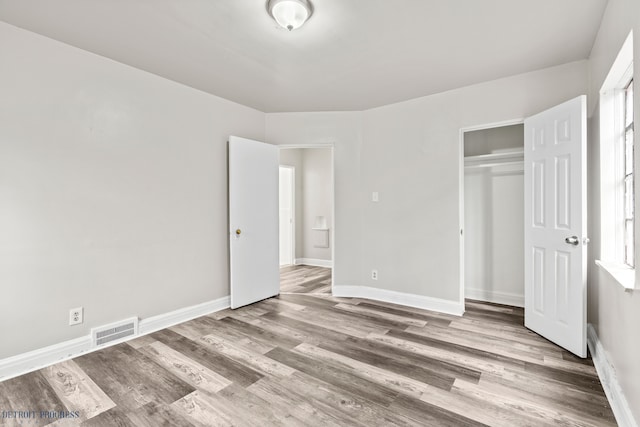 unfurnished bedroom featuring light hardwood / wood-style floors and a closet