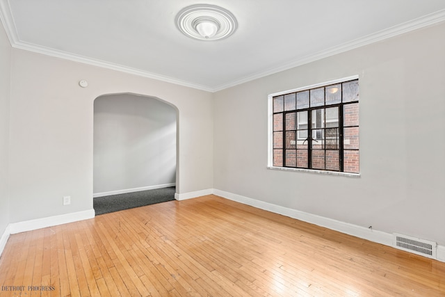 empty room with ornamental molding and hardwood / wood-style floors