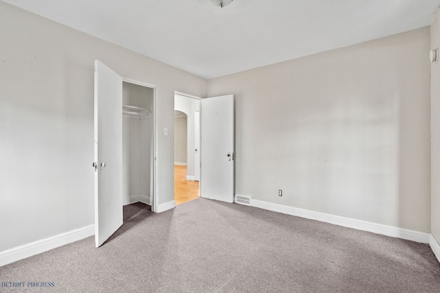 unfurnished bedroom featuring carpet and a closet