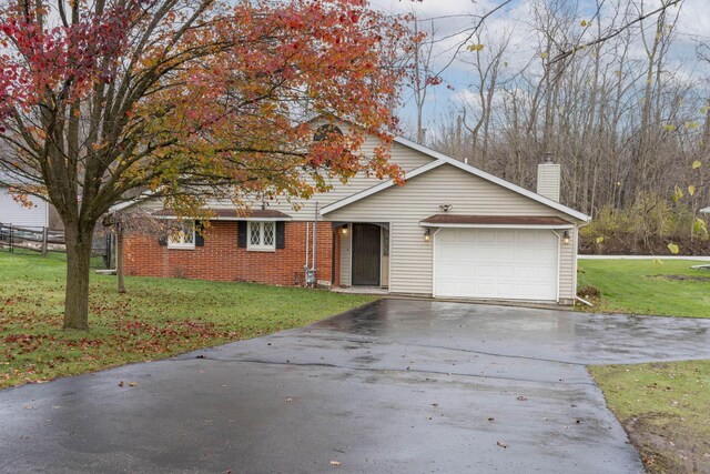 21734 N Channel Pkwy, Edwardsburg, MI 49112 - view of front of home with an attached garage, asphalt driveway, a chimney, a front yard, and brick siding