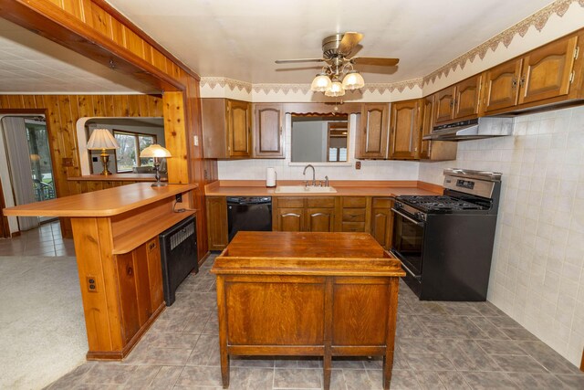 21734 N Channel Pkwy, Edwardsburg, MI 49112 - kitchen featuring stainless steel range with gas stovetop, black dishwasher, under cabinet range hood, a peninsula, and a center island