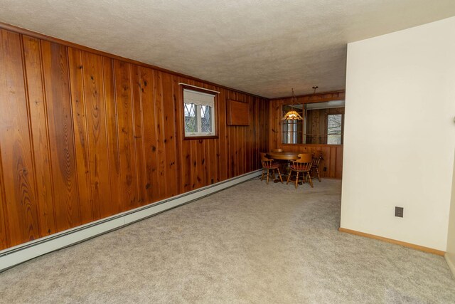 21734 N Channel Pkwy, Edwardsburg, MI 49112 - dining area featuring carpet flooring, wood walls, a baseboard radiator, and baseboards