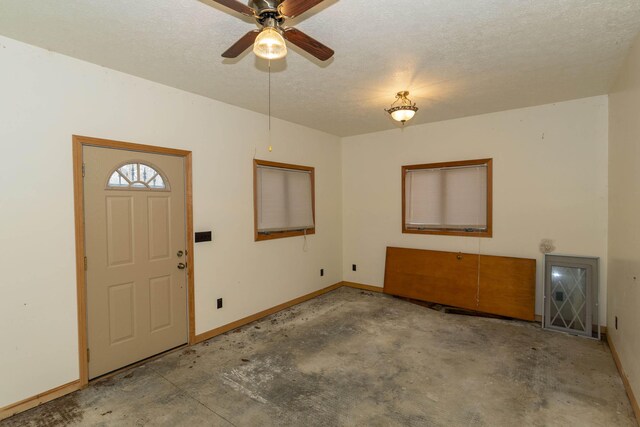 21734 N Channel Pkwy, Edwardsburg, MI 49112 - foyer featuring unfinished concrete floors, ceiling fan, baseboards, and a textured ceiling
